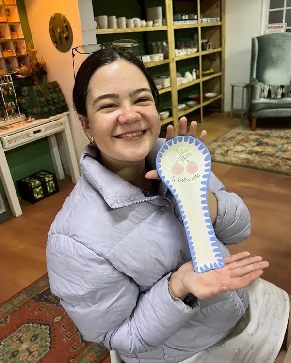 A customer smiling with her cherry spoon rest that says la dolce vita
